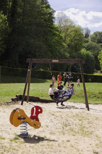 a group of people playing on a swing set in a park at Camping Le Florenville in Florenville