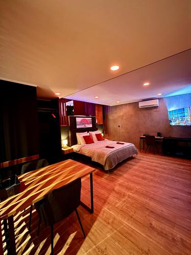 a bedroom with a bed and a table in it at Pause Thermale Suites Deluxe et Spa Privatif in Herstal
