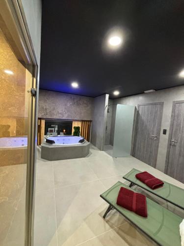 a large bathroom with a tub in the middle at Pause Thermale Suites Deluxe et Spa Privatif in Herstal