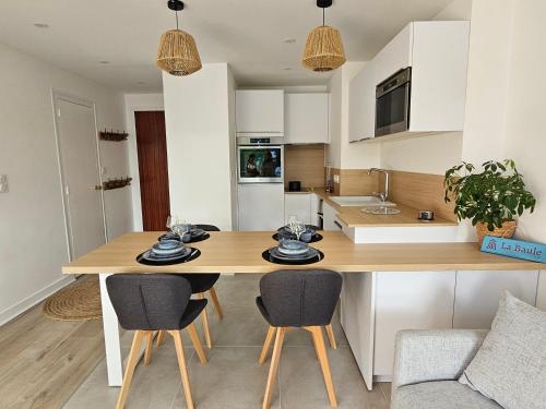 een keuken met een houten tafel en stoelen bij Le Capitole - Studio Plage Benoit - Escapade Hivernale in La Baule