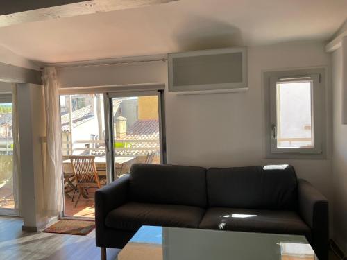 d'un salon avec un canapé et un balcon. dans l'établissement Appart Centre Mairie - Terrasse vue Ste Victoire, à Aix-en-Provence