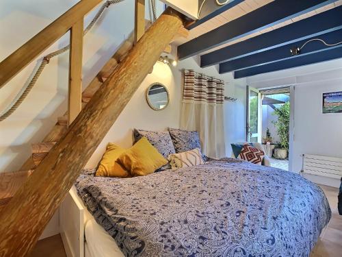 a bedroom with a bed with a blue comforter at Maison Trezma à 450m de la plage in Plonévez-Porzay