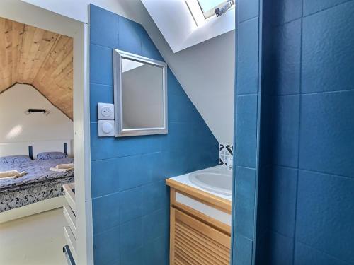 a blue bathroom with a sink and a mirror at Maison Trezma à 450m de la plage in Plonévez-Porzay