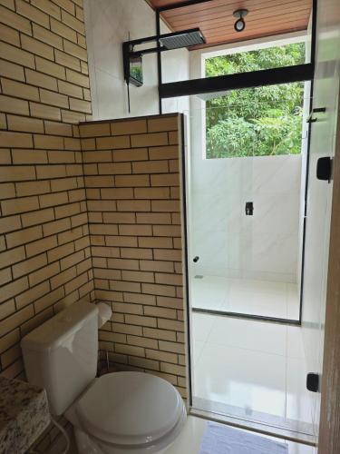 a bathroom with a toilet and a shower at Chalé Premium no Centro da Vila in Itaúnas