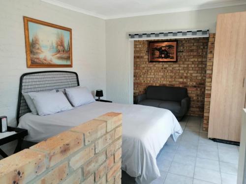 een slaapkamer met een bed en een bakstenen muur bij Charlie's Spot - Norwood in Johannesburg
