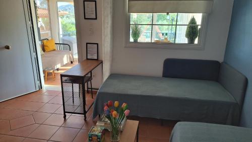 ein kleines Zimmer mit einem Bett und einem Tisch mit Blumen in der Unterkunft Kouklinos Cottage in Koropi