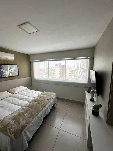 a bedroom with a large bed and a window at Flat Premium Recife - Ilha do leite piscina termica in Recife