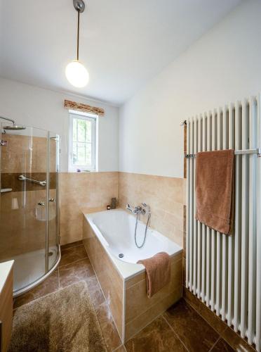 ein Badezimmer mit Badewanne und Glasdusche in der Unterkunft Villa Nußbaumer - Business-und Ferienwohnung in bester Lage in Arnstadt