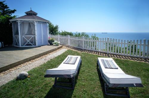 un cortile con due panchine e un gazebo di Будинок біля моря з басейном Одеса для 7 гостей - 3 спальні a Odessa