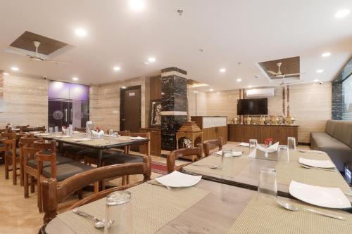 a restaurant with tables and chairs and a couch at Townhouse DJ Grand in Tirupati