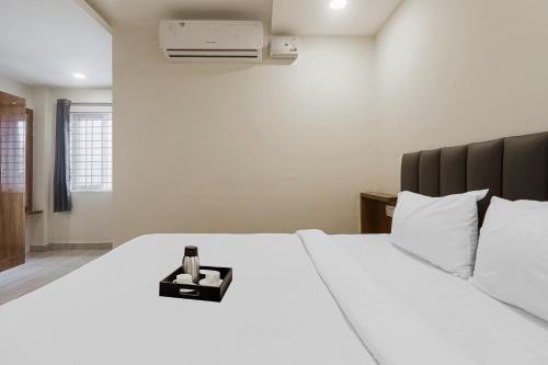 a white bed with a bottle of champagne on it at Townhouse DJ Grand in Tirupati