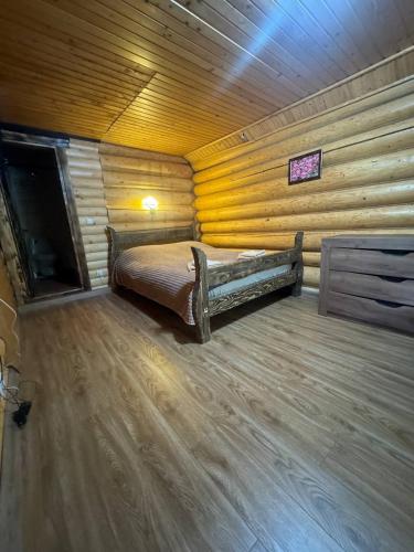 a room with a bed in a log cabin at Садиба Верховинський водограй in Synevyrsʼka Polyana