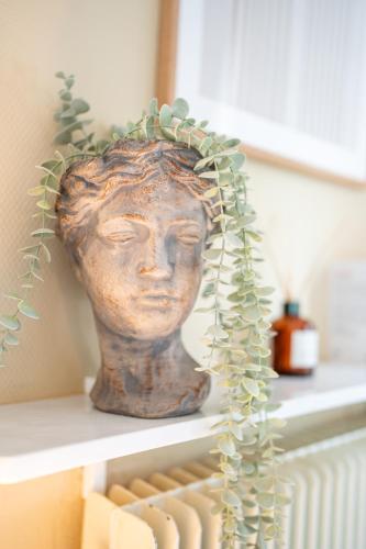 une statue d'une tête assise sur une étagère dans l'établissement Villa Vichéia - Appartement 33, à Vichy