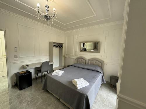 a bedroom with a bed and a desk and a chandelier at Blue Sky in Tropea