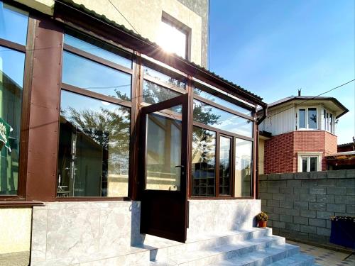 une maison en verre avec une porte et des escaliers dans l'établissement Da! Hostel, à Bishkek
