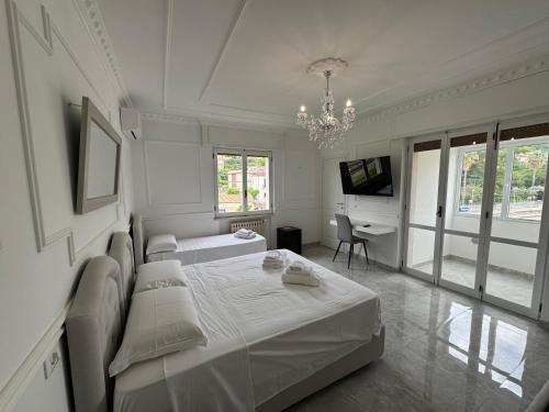 a white bedroom with a bed and a desk at Blue Sky in Tropea