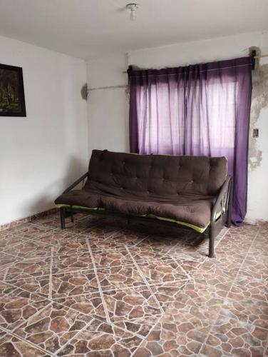 a brown couch in a room with a purple curtain at Casa Valle de Sur in Durango