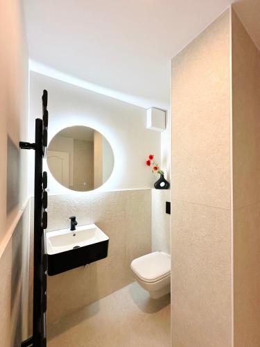 a bathroom with a white toilet and a sink at Yutori - Apartment in Malchow