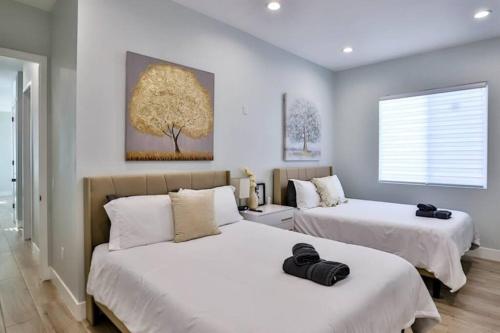 two beds in a room with white walls at H&H New Built 2023 Hidden Gem Heart of OC 3 Queen Beds in Westminster