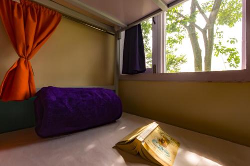 a purple bed in a room with a window at Dormigo in Bīr