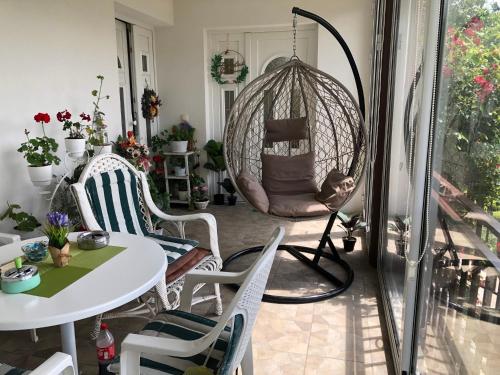 a porch with a swing and a table and chairs at Apartment Vila MM Srce in Vrdnik