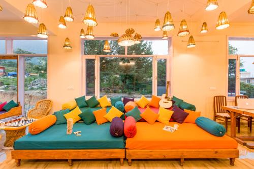 a room with a couch with colorful pillows on it at Dormigo in Bīr