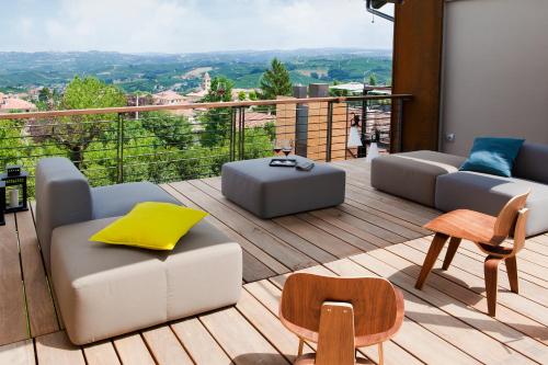a balcony with couches and tables and a view at Arborina Relais in La Morra