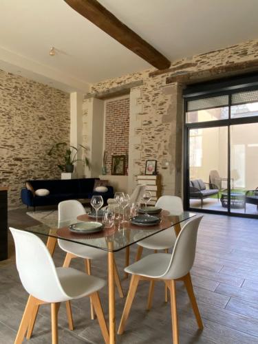 une salle à manger avec une table et des chaises blanches dans l'établissement La Sellerie - Loft de luxe au cœur d'Angers, à Angers