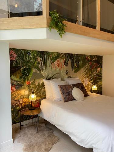 - une chambre avec un lit blanc et un mur de plantes dans l'établissement La Sellerie - Loft de luxe au cœur d'Angers, à Angers