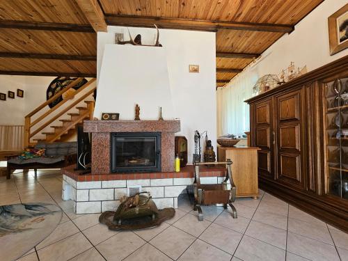 a living room with a fireplace and a staircase at Ferienhaus JULKA am See mit Kamin & WLAN - Domek Letniskowy JULKA in Teerau