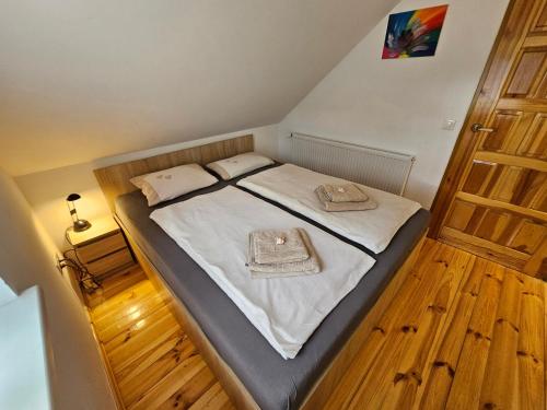 a small bedroom with a bed with white sheets at Ferienhaus JULKA am See mit Kamin & WLAN - Domek Letniskowy JULKA in Teerau