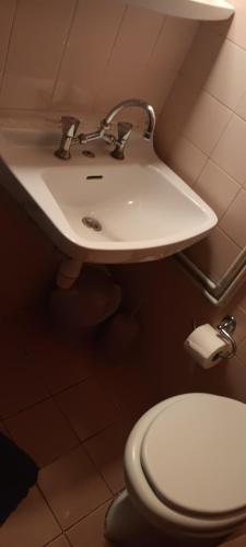 a bathroom with a white toilet and a sink at Hotel zakros rooms-restaurant in Zákros
