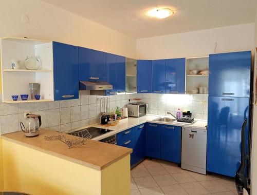 eine Küche mit blauen Schränken und einem blauen Kühlschrank in der Unterkunft Apartment near beach with free parking in Kaštela
