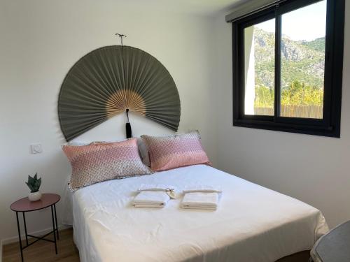 エズにあるUn coin de paradis avec vue Mer et jardinの大きなベッドとタオル2枚のある寝室