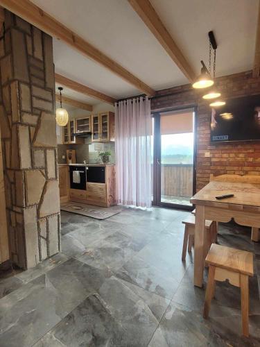 a kitchen with a table and a stone wall at NR2 Osada pod giewontem in Czerwienne