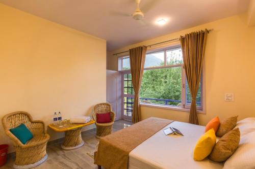 a bedroom with a bed and a large window at Dormigo in Bīr