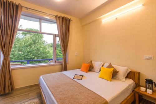 a bedroom with a bed with a large window at Dormigo in Bīr
