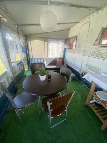 a dining table and chairs in an rv at AMOMEA CAMP in Jastarnia
