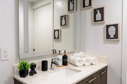 a bathroom with a sink and a mirror and towels at Vibrant Downtown Miami Gem - 2BR, near Port of Miami & Entertainment in Miami
