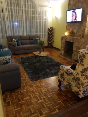 uma sala de estar com um sofá e uma lareira em Teresita Home em Nairobi