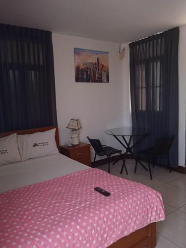 皮門泰爾的住宿－Hotel Garuda Pimentel，一间卧室配有一张床和一张桌子及椅子