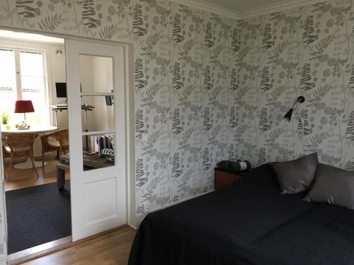 a bedroom with a bed and a mirror and a table at Björnnästet med havsutsikt innanför murarna in Visby