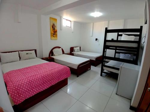 1 dormitorio con 2 camas y 1 litera en Hotel Garuda Pimentel, en Pimentel