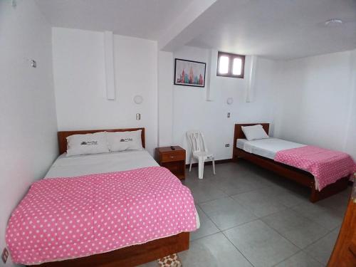 ein Schlafzimmer mit 2 Betten und einem Stuhl darin in der Unterkunft Hotel Garuda Pimentel in Pimentel