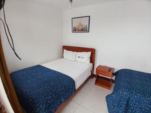 um pequeno quarto com 2 camas e uma mesa de cabeceira em Hotel Garuda Pimentel em Pimentel