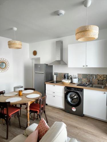 une cuisine avec une table et une machine à laver dans l'établissement Mar&Sol Charmant appartement de type 2, à La Rochelle