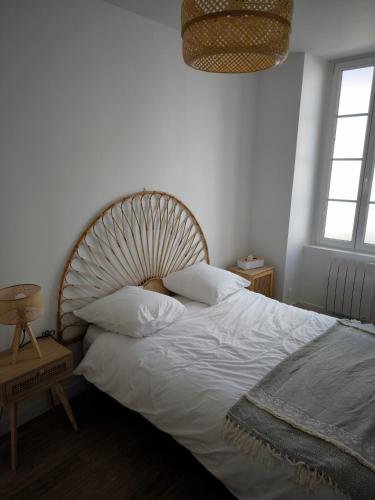 une chambre avec un grand lit avec des draps et des oreillers blancs dans l'établissement Mar&Sol Charmant appartement de type 2, à La Rochelle