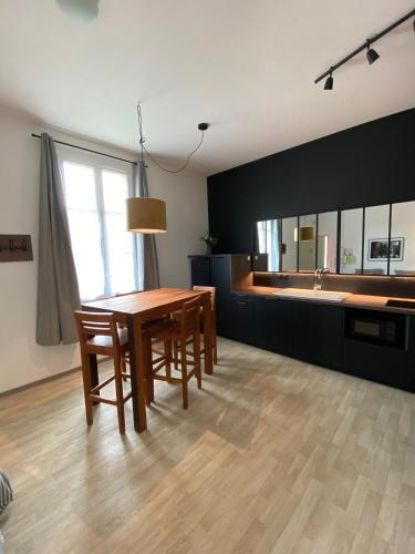 - une salle à manger avec une table et un lavabo dans l'établissement Appartements Soulac - hyper centre et plage, à Soulac-sur-Mer