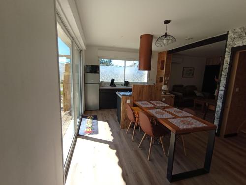 une salle à manger et une cuisine avec une table et des chaises dans l'établissement La maison du bout, à Créances