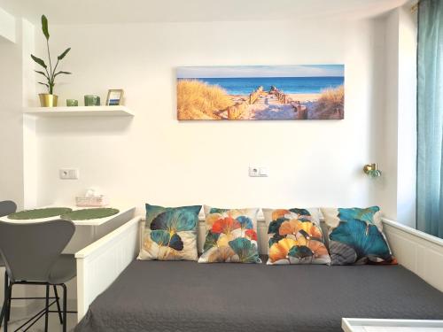 a couch in a living room with a picture on the wall at Apartamento estudio “The mirror” in Torrevieja